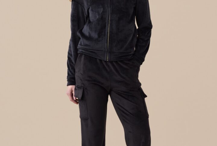 Modella indossa completo donna in ciniglia felpata nero Noidinotte con zip e pantaloni con tasche a toppa