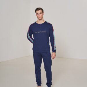 Uomo con indosso pigiama lungo Sergio Tacchini blu con maniche a righe