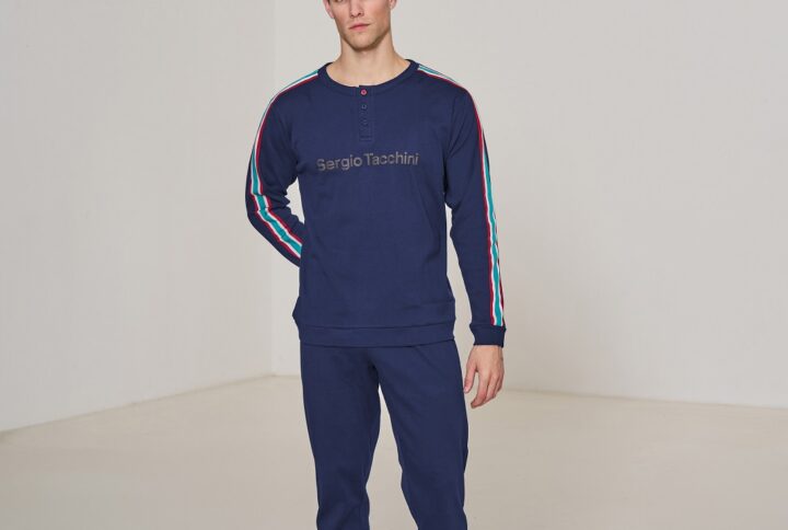 Uomo con indosso pigiama lungo Sergio Tacchini blu con maniche a righe
